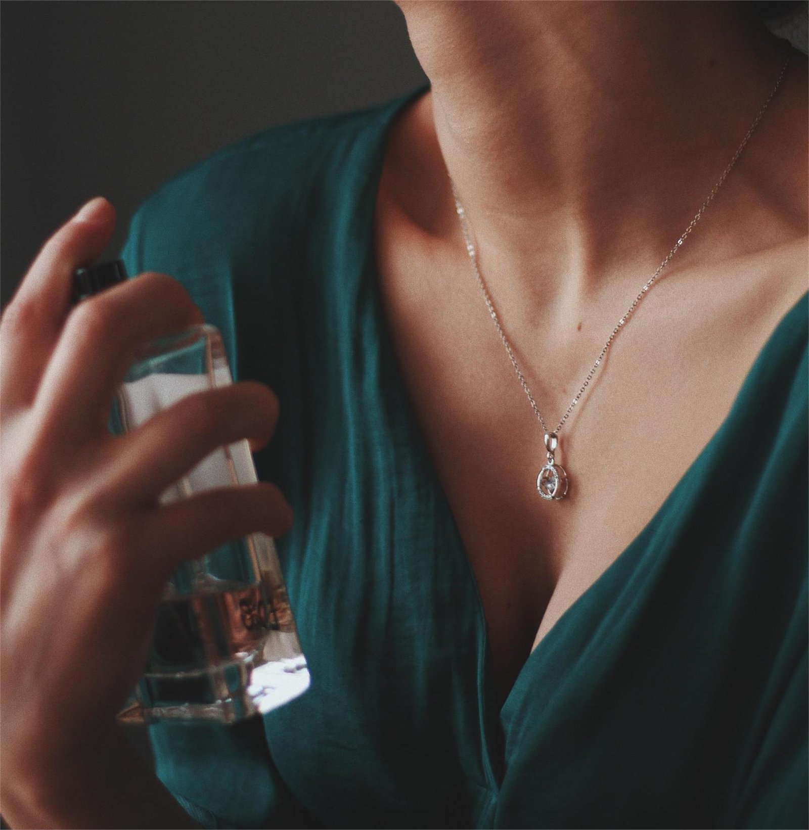 Mujer aplicando perfume en el cuello, muestra práctica de como saber si un perfume es original.