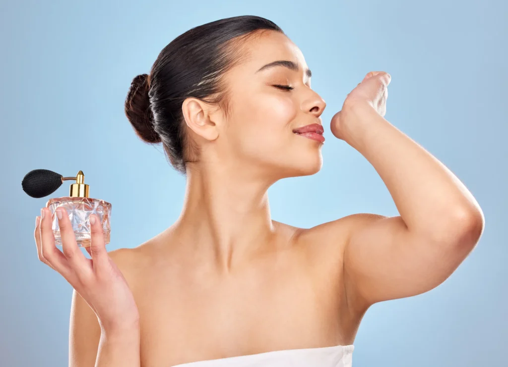 Mujer sonriendo mientras prueba un perfume decant, ideal para entender qué es un decant