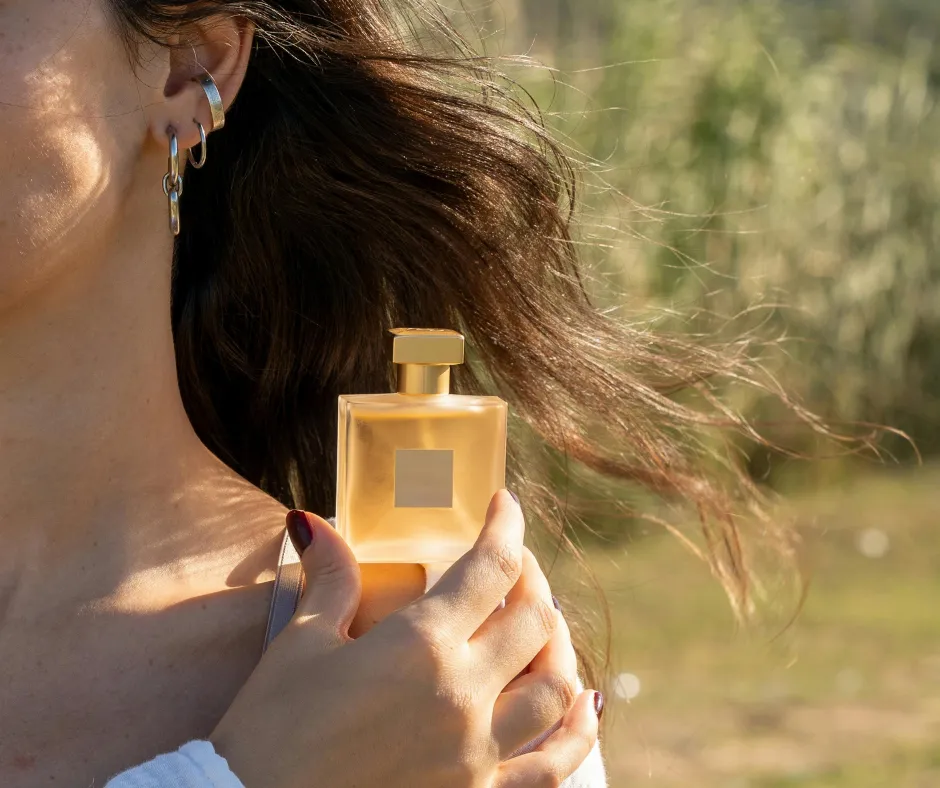 Mujer aplicando perfumes decants directamente en la piel para probar cómo evoluciona la fragancia durante el día