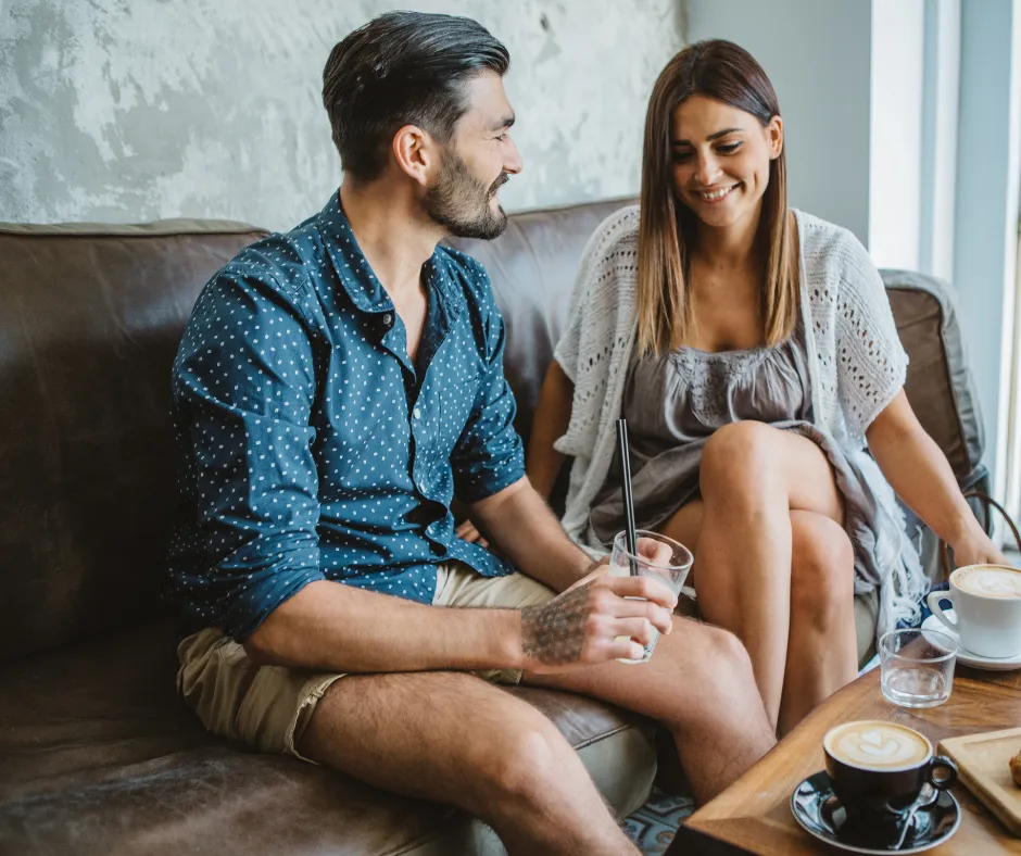 Hombre en una cita con una mujer mientras comparten una bebida, reflejando perfumes para hombre ideales para momentos románticos