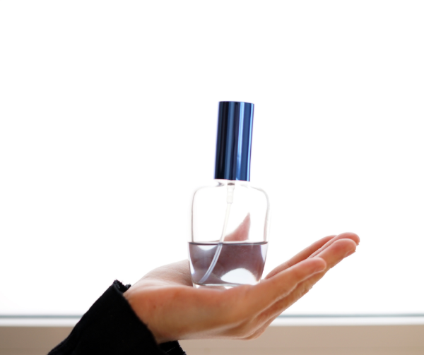 ¿Qué significa que un perfume sea decant? Decant original de 30 ml con tapa azul sostenido en la mano